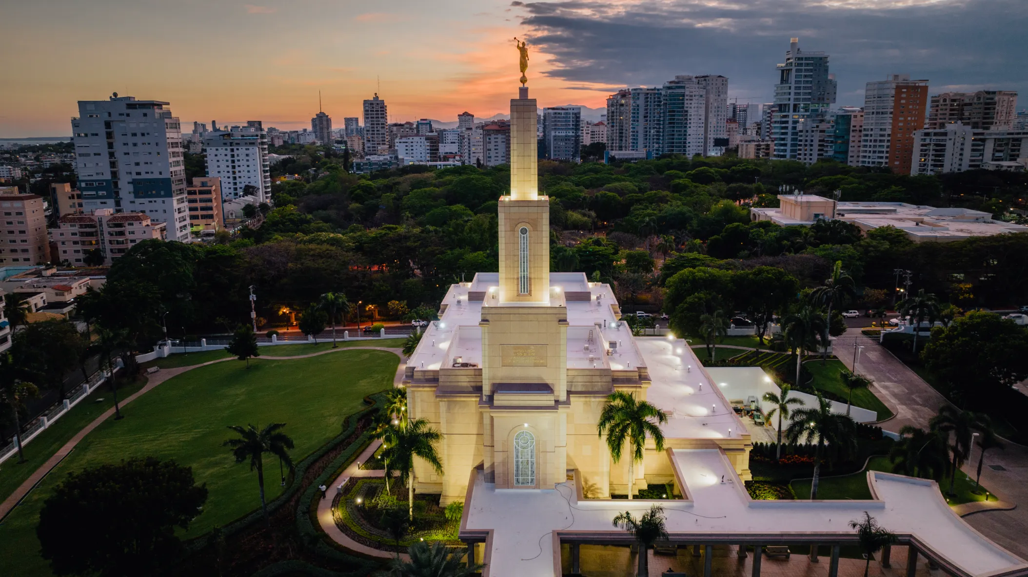 Iglesia monumentalcon perspectiva aérea al atardecer Fotografía comercial aérea de iglesia iluminada al atardecer en Santo Domingo con perspectiva drone, cielo dorado y ciudad de fondo